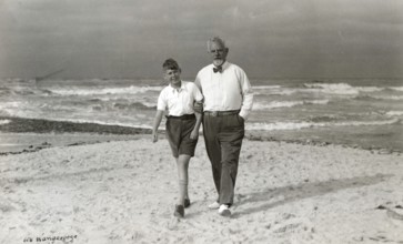 Grandpa and grandson on the beach of Wangerooge, 1930s, Elderly man and boy walking along the