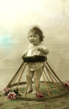 Baby in a frame, walking aid, 1910s, A baby stands in a tyre with flowers, in retro style,