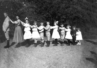 Large family posing in size, organ pipes, 1920s, children in a row, holding each other by the