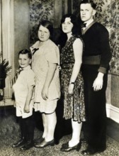Family photo set up according to size, 1920s, Four people posing standing for a family portrait,