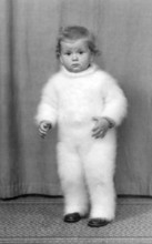 Toddler with funny romper suit, 1930s, Toddler in a fluffy suit, standing on a carpet, looking