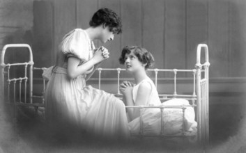 Two woman praying, 1930s, Two woman talking intimately on a bed, Historical photo