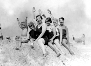 Family on a pile of sand, 1930s, group of people in swimming costumes, sitting happily on the