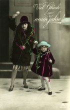 Good luck in the new year, 1930s, Two woman and a child throw snowballs and wish a happy new year,