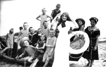 Children's leisure time, 1920s, children in striped clothes and a woman posing smiling on the beach