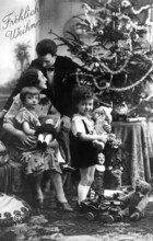 Family Christmas tree, 1930s, Christmas family scene with decorated tree, parents and children with