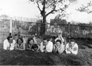 Large family lying in a row in the grass, 1930s, A group of people lying relaxed in the meadow on a