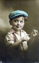 Little boy with a cigarette, 1930s, A boy in a colourful cap and shirt playfully holds a cigar and