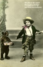 Boy with toy bear on a leash, 1910s, A child poses with a small bear carrying a toy box, Historical