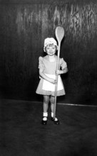 Girl with a large wooden spoon, 1930, A little girl in a costume proudly holds an oversized wooden
