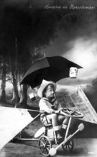 Boy with strange vehicle, 1900, A boy sits on a tricycle, holding an umbrella in a surreal-looking