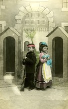 2 children dressed up, 1920, Two children in costumes with toy gun, in front of a painted scenery,