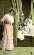 Mother with 2 girls, 1910, Three woman in Victorian dresses posing in front of green curtains,