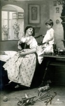 Child playing with mum's hair, 1920, A woman and a boy are inside, surrounded by toys, in a