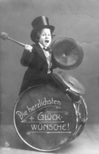 Child with a drum, 1920s, child in top hat plays drum and cymbal, labelled 'The warmest