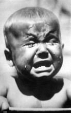 Crying child, 1920, A little boy cries bitterly, tears stream down his face in a black and white
