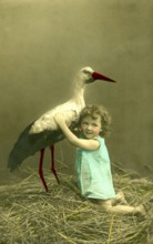 Girl with stork, 1910s, A child embraces a stork in a nest, surrounded by nature, Historical photo