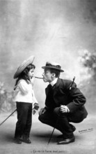 Man gives girl a light, 1910, A man in a suit and a girl exchange humorous glances while smoking a