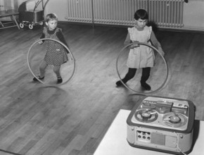 Two children playing with the Hulahup tyre, 1950s, Two girls dancing with tyres in front of a tape