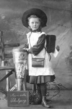 School enrolment, 1910s, girl with school bag and historical clothes, celebrating the start of