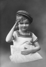 Little boy, 1920s, child with cap holding a newspaper and greeting, black and white photo with
