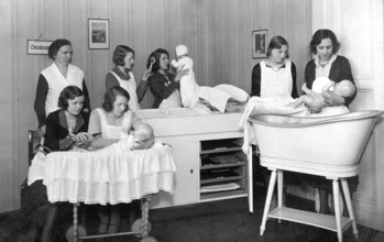 Midwifery school, 1930s, woman in uniforms, caring for dolls in a classical room, training