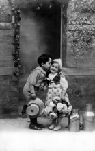 Boy kisses girl, 1920s, A boy kisses a girl on the cheek, surrounded by flowers and pewter cans,