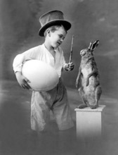 Boy with egg and rabbit, 1930s, Young pantomime with top hat presents a rabbit with magic wand and