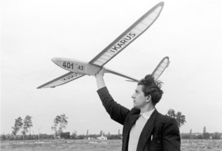 Man with model aeroplane, 1930s, A man poses outdoors with a model aeroplane in front of a cloudy