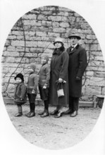Family standing in a row, 1930s, Family in winter clothes standing together in front of a stone