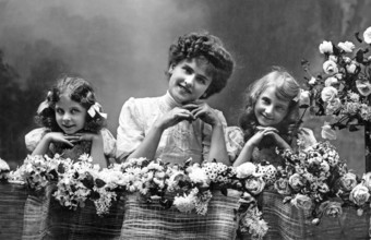Woman with two girls, 1920s, Two girls and a woman smiling over a flower arrangement, Historical
