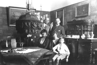 Family photo, 1920s, Family scene in an antique furnished living room with paintings and furniture,