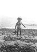 Little girl on the beach, 1920s, Young boy on the beach with bucket in hand, black and white