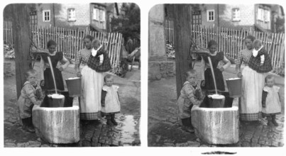 Women fetching water, 1920s, Women and children at water pump in courtyard, showing everyday scene,