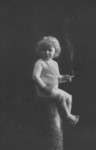 Child smoking, 1920s, A child in historical clothing sits on a pedestal and holds a cigarette in