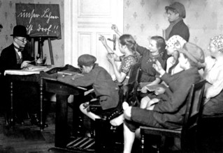 Young people playing school, ca. 1920, children in the classroom writing with pencils while the