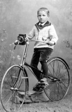 Boy on bicycle, 1930s, A young boy poses with a bicycle in a studio, Historical photo
