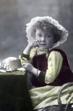 Girl knitting, 1930s, A young girl sits with a crochet set and looks thoughtfully into the camera,