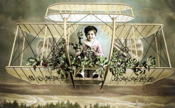 Child in aeroplane, 1920s, A child sits in a decorative old aeroplane, surrounded by plants,