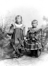 Two girls in Sunday dresses, 1920s, Two children in old-fashioned clothes in front of a painted