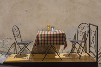 A small table and two chairs in the street in front of a café, Montepulciano, Province of Siena,