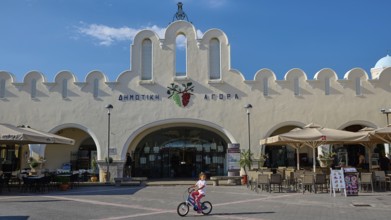 Traditional market square with iconic architecture and playing child, Agora, Market Hall, Kos Town,