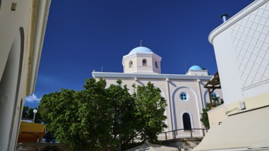 Mediterranean church with blue dome and green trees under a blue sky, Agia Paraskevi Church, Kos