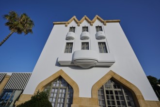 Modern white building with balconies and palm trees, clear, sunny atmosphere, Boutique Hotel