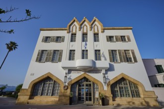 Historic building with striking architecture and symmetrical windows against a blue sky, boutique
