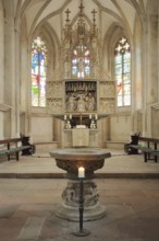 High altar and baptismal font of the Romanesque St. Mary's Church, interior view, colourful church