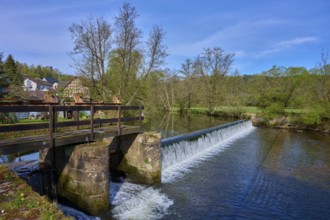 A weir bridges a river, surrounded by fresh green trees, spring, Obersinn, Sinntal, Spessart,