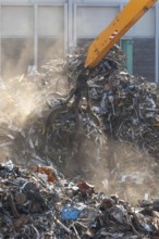 Hydraulic crane lifts scrap metal at the scrap yard