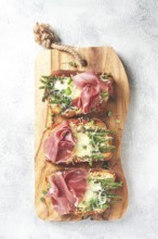 Open sandwiches with asparagus and prosciutto, with cheese, breakfast, on a wooden serving board