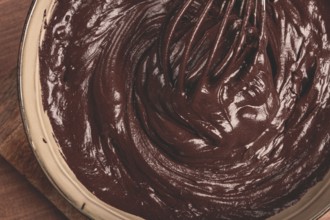 A bowl of chocolate dough, a whisk for whipping, baking, structure and consistency, homemade, top